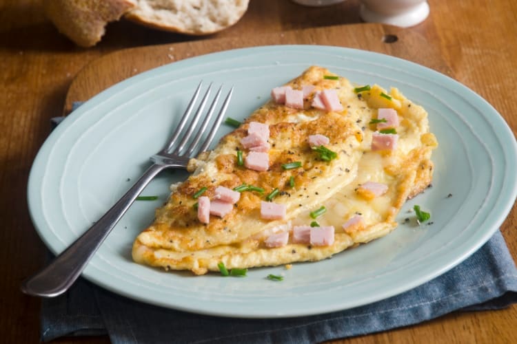 A ham and cheese omelette on a light blue plate