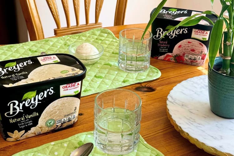 Tubs of Natural Vanilla and Natural Strawberry Breyers ice cream flavors on a wooden table