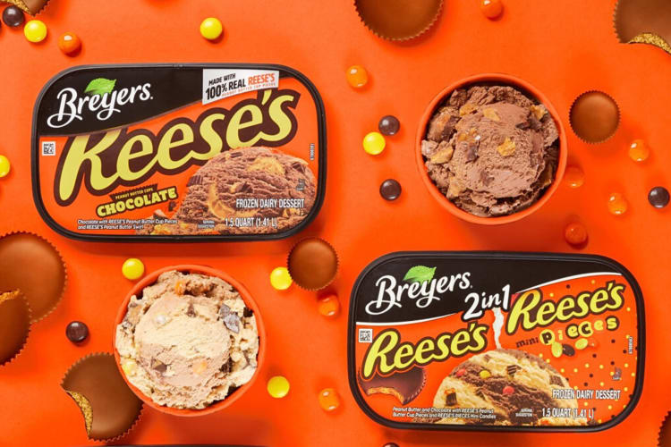 Two Reese's Breyers ice cream flavors on an orange background surrounded by candy