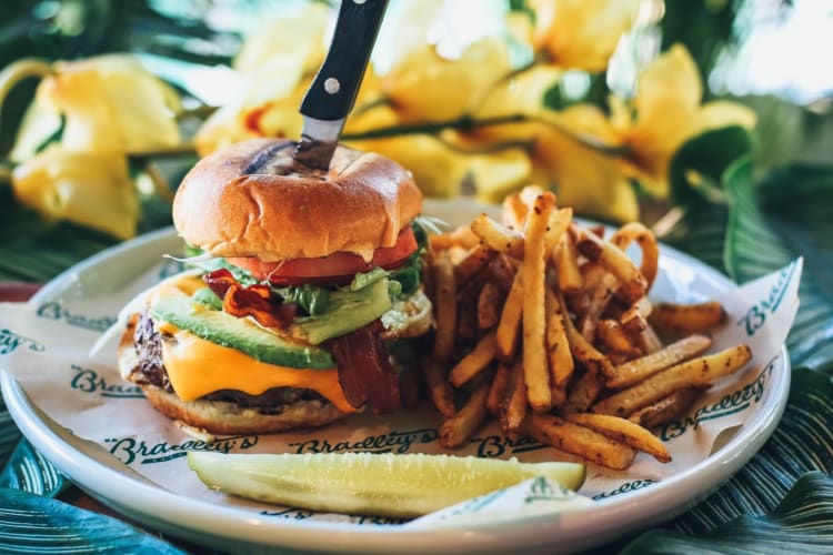 a loaded cheeseburger with a side of fries