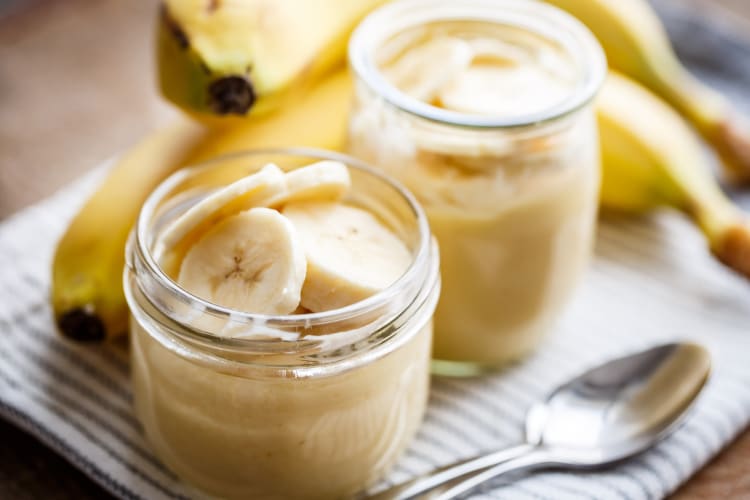 Banana pudding in jars served with sliced bananas