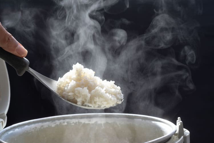 Freshly cooked white rice, steaming on a spoon.
