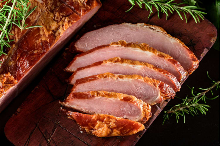 Sliced ham served with rosemary