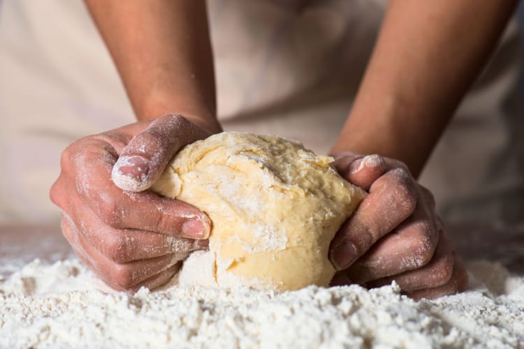 Man kneading pizza dough