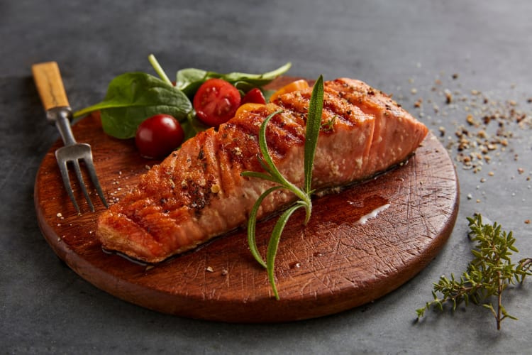 Grilled salmon served on a wooden board