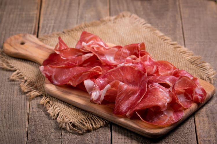 Sliced capicola on a cutting board