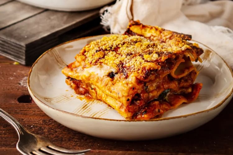 A portion of béchamel lasagna in a white bowl
