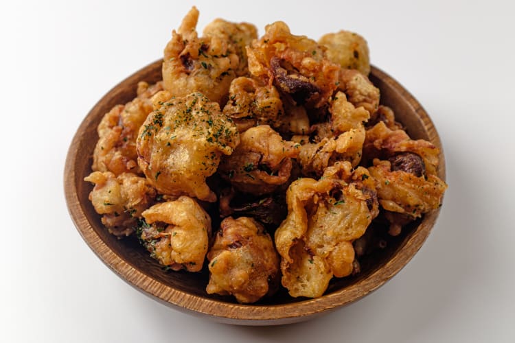 Fried gizzards served on a wooden plate