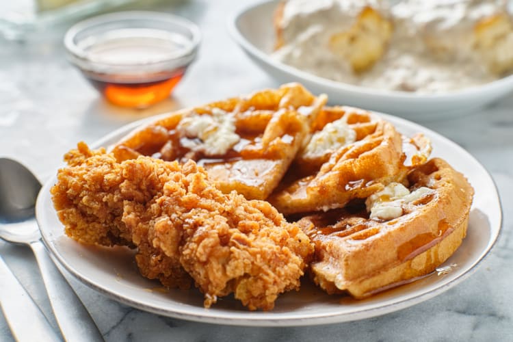 Chicken and waffles served with butter and syrup