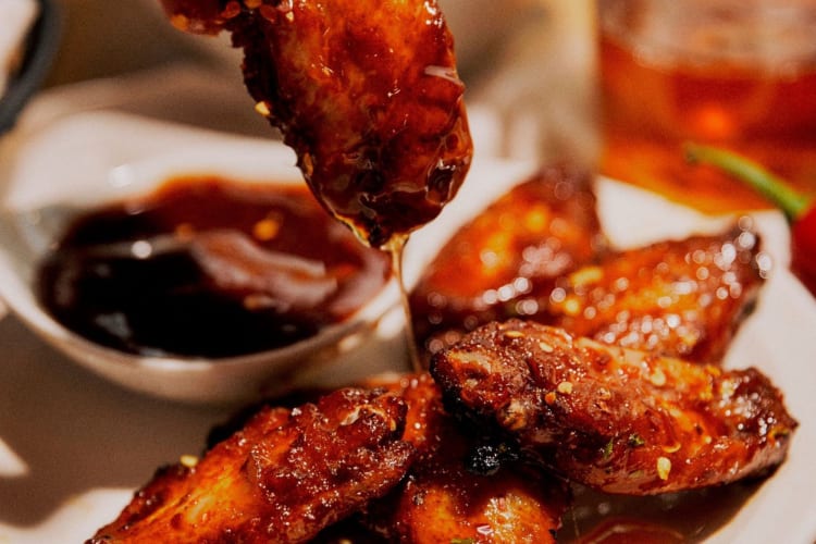 Sayap ayam dan saus lengket yang lezat.