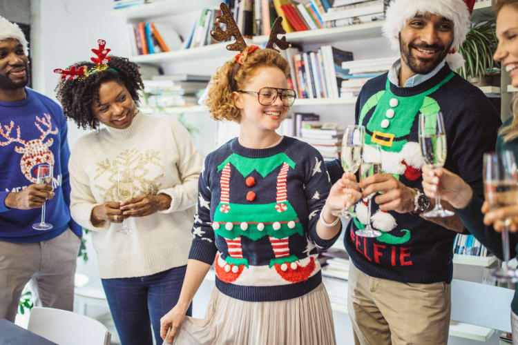 People wearing Christmas sweaters at a party