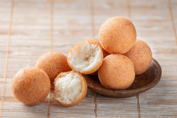 Seven buñuelos, a tasty Cinco de Mayo food, on a small wooden bowl