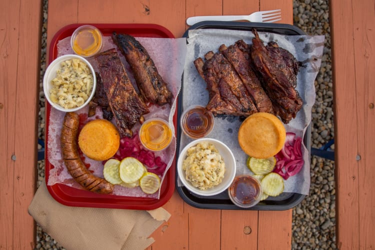 Pork ribs served with mac and cheese, cornbread and salad with pickles