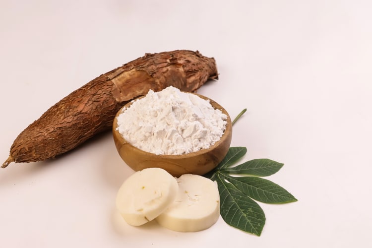 A tapioca root next to tapioca flour in a bowl — a great cornstarch substitute