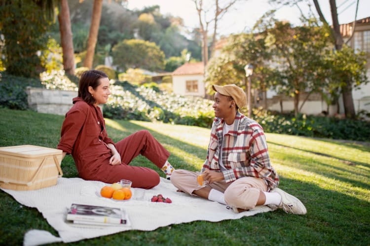 couple smiling while having a picnic at the park