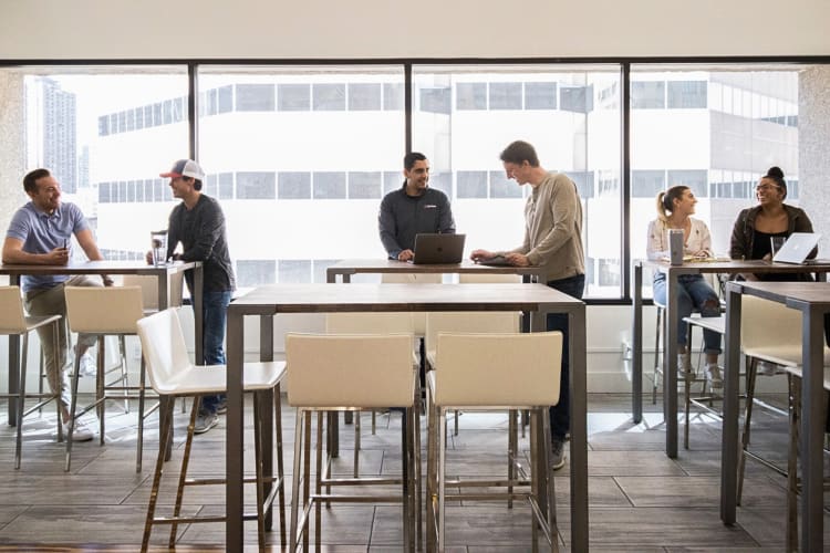 Three pairs of two people chatting to one another in a work area at Expansive
