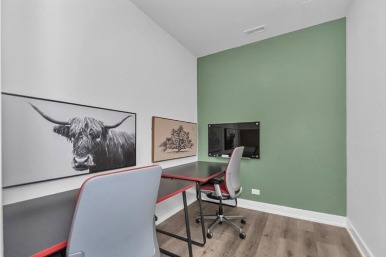 A workspace with two chairs and two tables, at Windy City Coworking