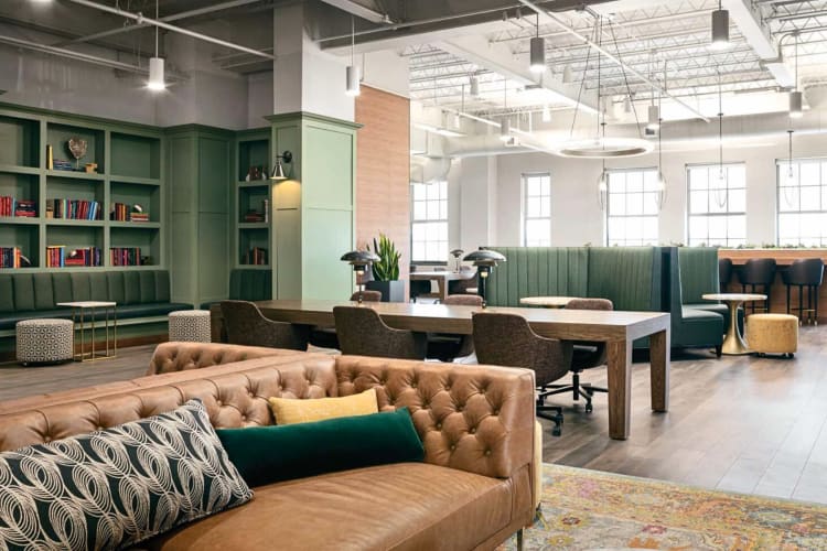 A communal area with tables, chairs and couches for work and relaxation, at Life Time Work