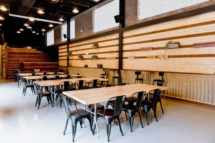 A working/events area with chairs and wooden tables, at Guild Row