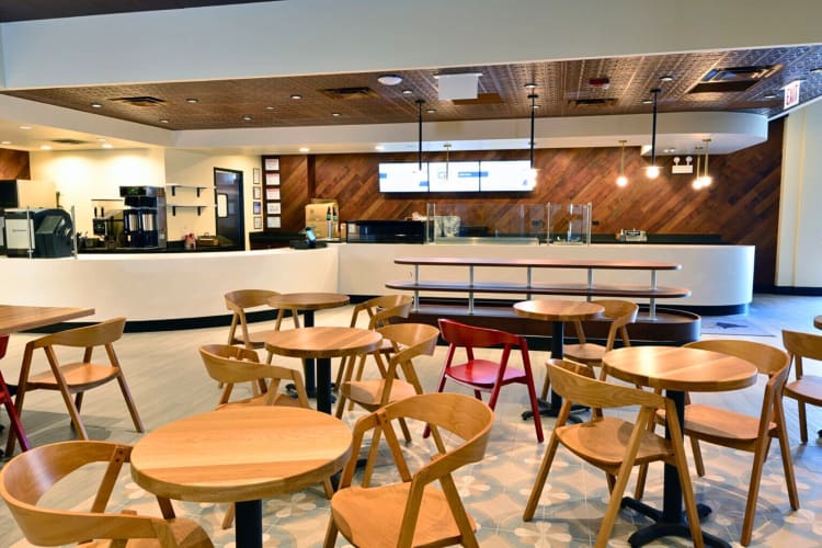 A communal seating area in front of a café, at Office Evolution Chicago-O'Hare