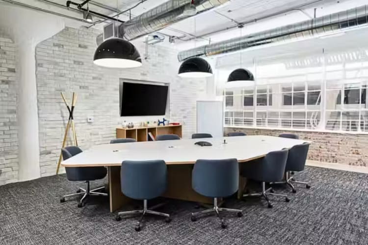 A meeting room with a table, chairs and a TV, at Spaces The Arts District