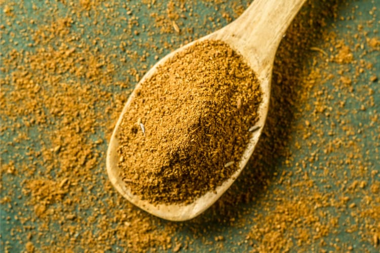 Cumin on a wooden spoon