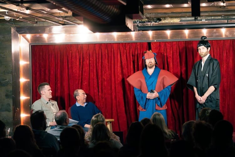 Four people on stage during a comedy show at Acme Comedy Company