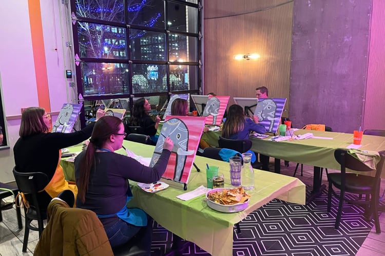 People painting at Wine and Canvas, a great place to organize a date idea in Minneapolis