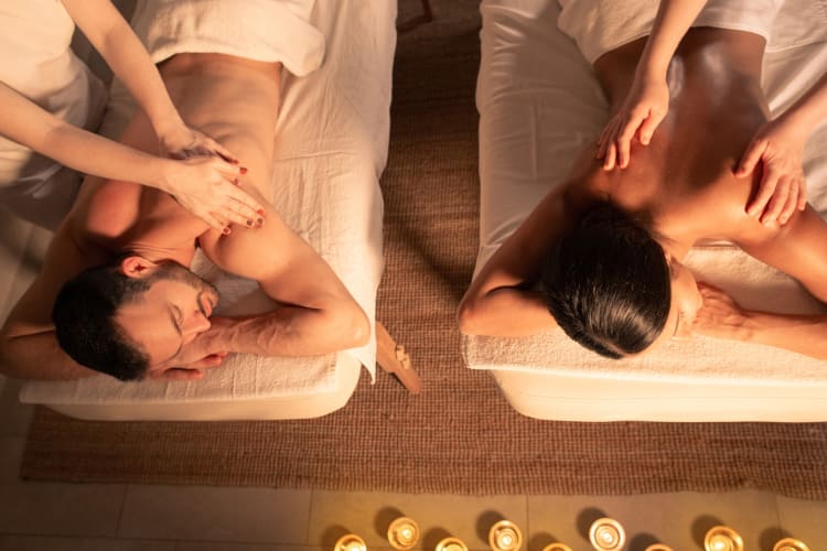 a couple receiving a couples massage in a dim room