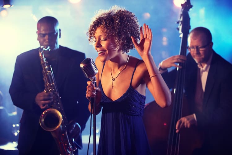 Three people performing in a jazz band — a great performance to watch during a date night in NYC