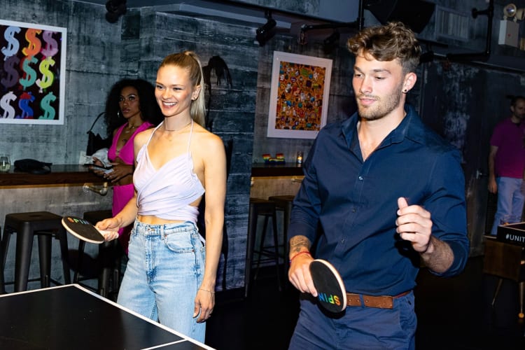 A man and woman playing ping pong at SPiN, a popular activity for a date night in NYC