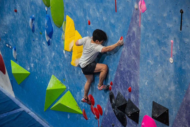 A man rock climbing at Movement Gym, a fun idea for a date night in NYC