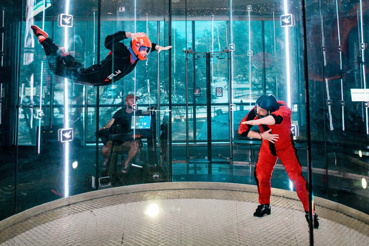 An instructor teaching someone how to skydive at iFLY