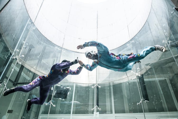 Two people skydiving indoors — a great idea for a date night in NYC
