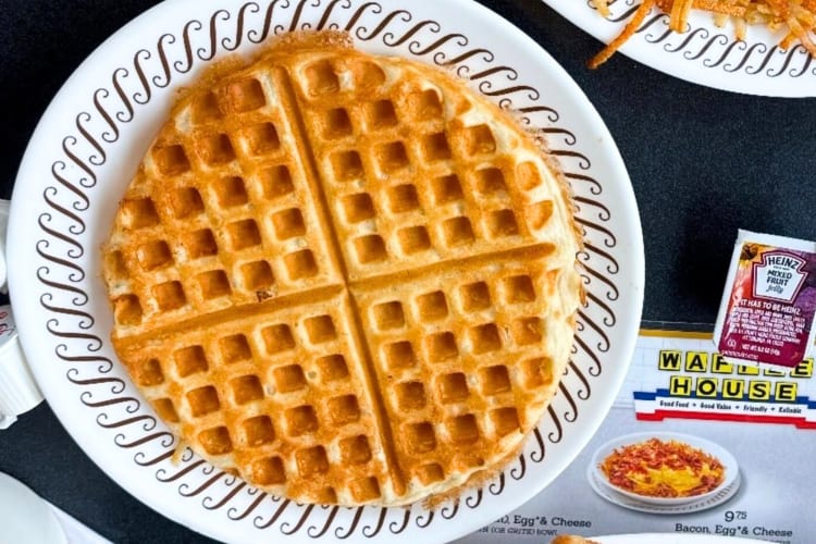 A waffle next to a menu and a small ketchup container, from Waffle House, a diner in Fort Worth