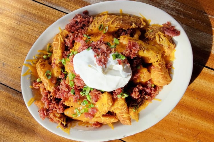 Potatoes topped with shredded cheddar, chopped bacon, green onions and sour cream