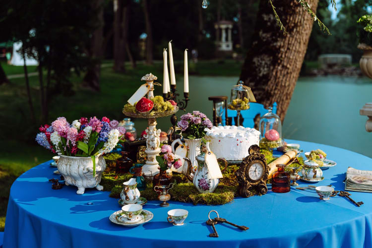 An Alice in Wonderland table setup in an outdoor setting