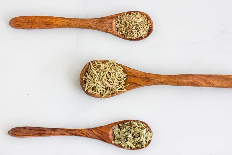 Dried mixed herbs on wooden spoons