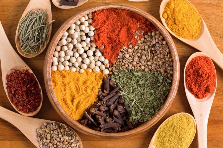 Spices on a wooden bowl and spoons