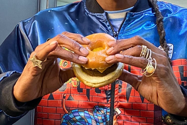 Hands holding the Dunkin' Donuts Beyond D-O-Double G Sandwich