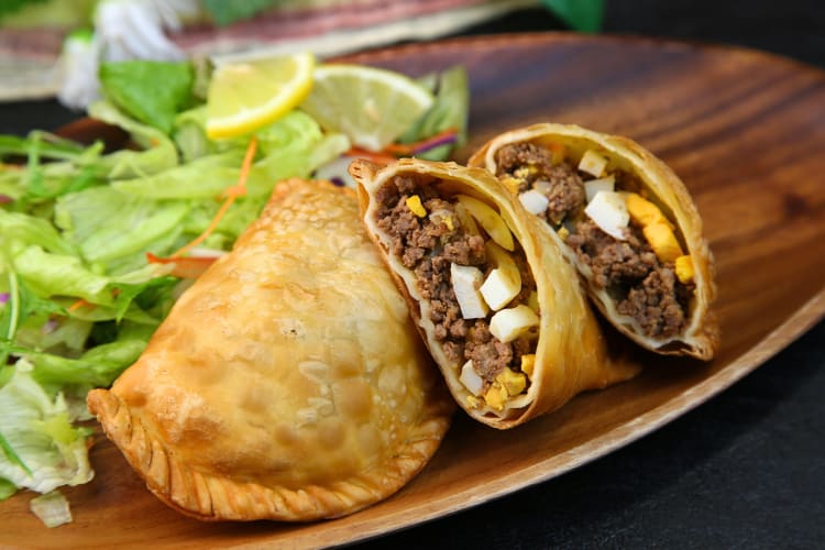 One whole empanada with two halves next to it