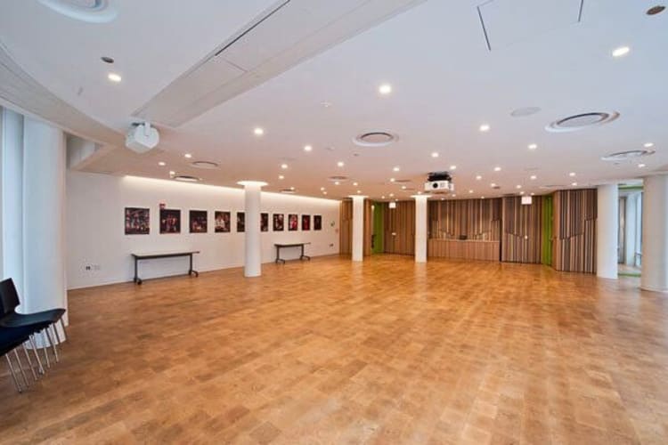 An open area with a wooden floor and a projector, at Goodman Theatre, an event space in Chicago