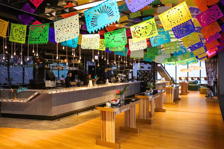 A bar area in 360 CHICAGO Observation Deck decorated with overhead square flags