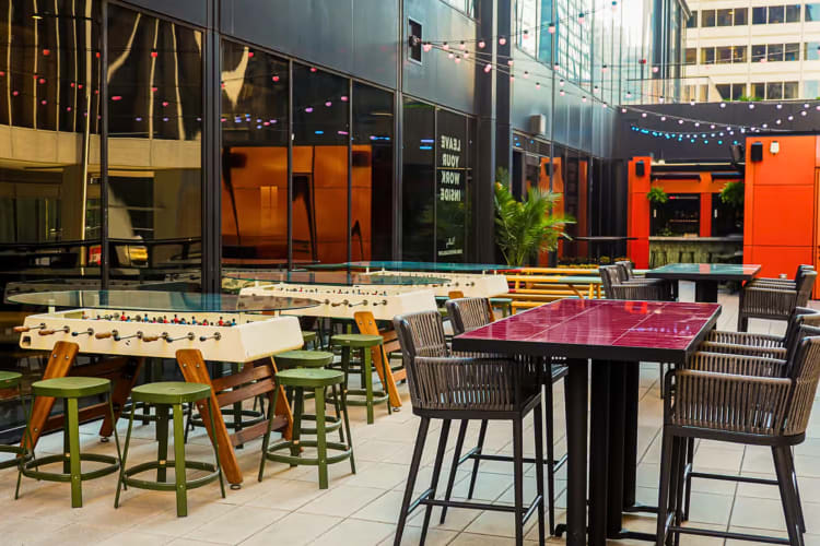 An outdoor area at Kindling with tables, chairs and foosball tables
