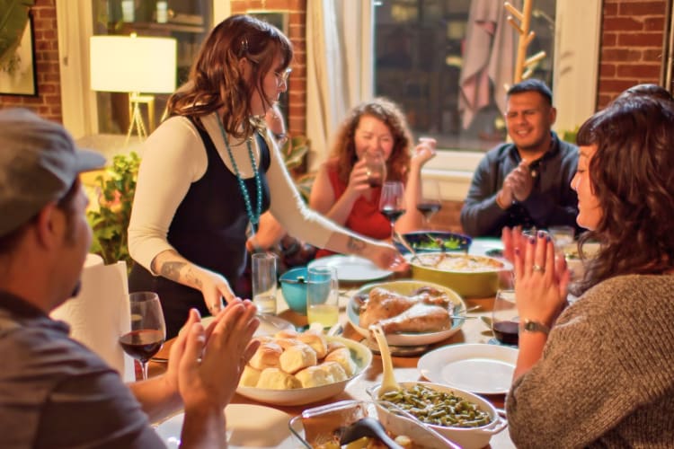Friends gathering at a table eating dinner. 