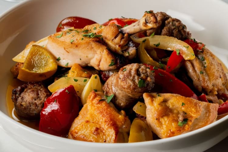 Chicken served with sausage, peppers and onions