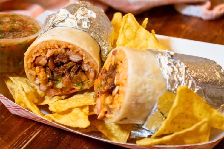 Super al pastor burrito served with chips