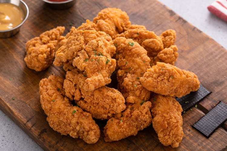 Chicken tenders on a wooden serving board