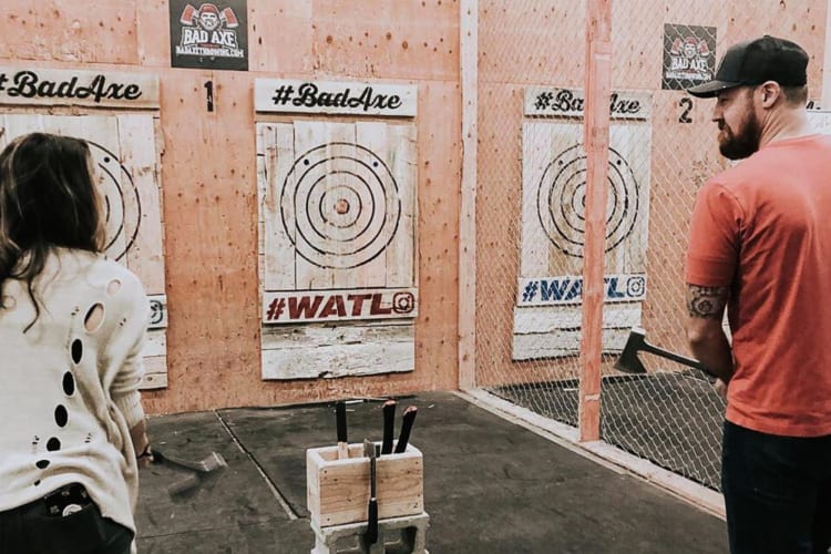 A man and woman talking before throwing axes at Bad Axe Throwing