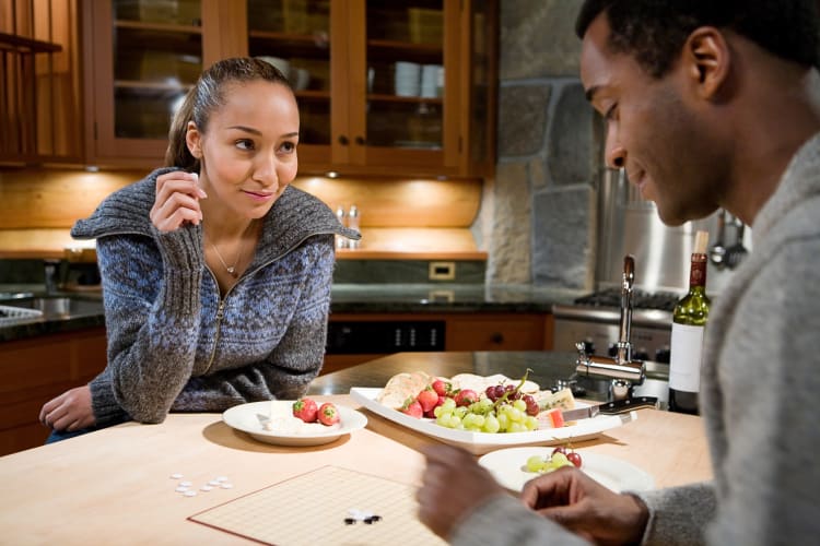 A man and woman playing a board game, which is a fun first date idea